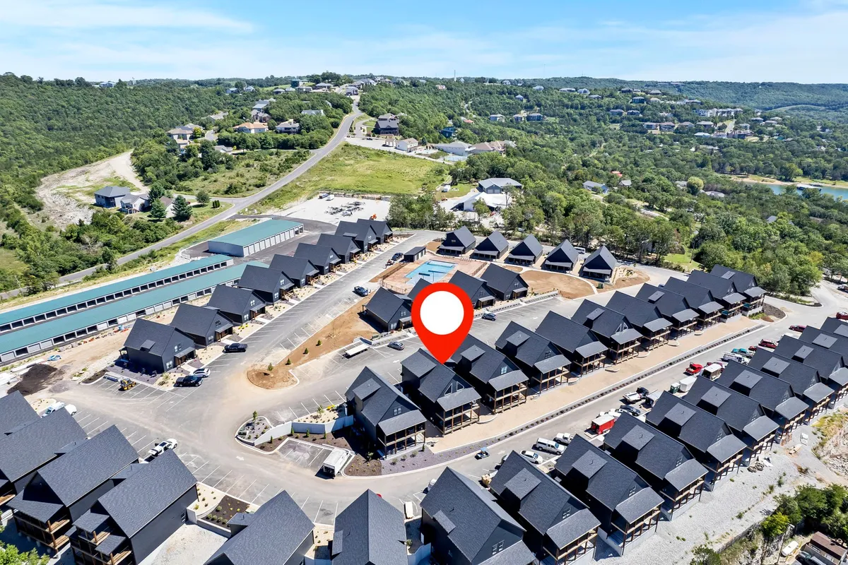 A cluster of houses surrounded by greenery, with connecting roadways and ample open communal spaces. The neighborhood appears inviting and designed for outdoor leisure, with areas suitable for walks and social gatherings.