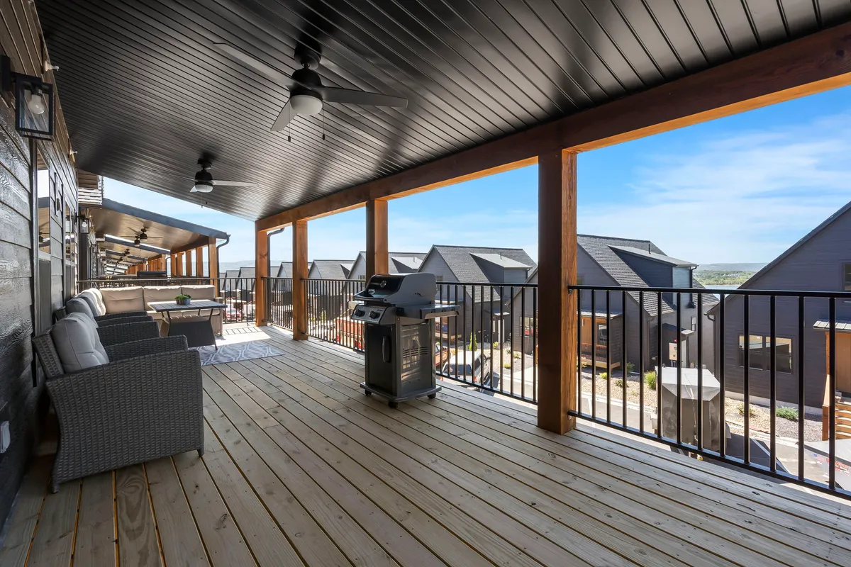 A well-appointed outdoor deck with comfortable seating, a grill, and open views of the surrounding houses. The setting is ideal for barbecues, relaxing with friends, and enjoying fresh air or sunset views over the lake.